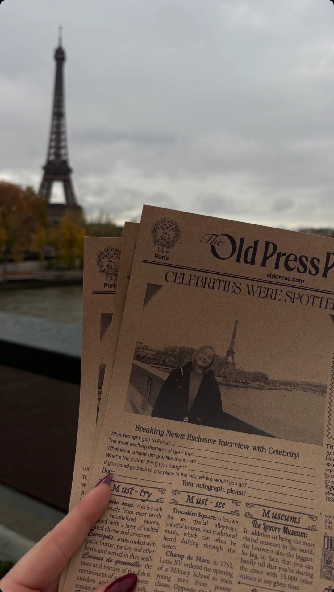 Stack of Paris Old Press newspapers held up with the Eiffel Tower behind